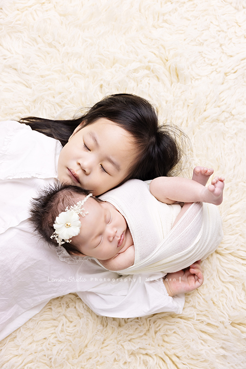 Fiamma一家第二次來拍照，這次是可愛的妹妹的新生兒寫真，這張是姊姊躺在二寶旁的兩人合照！