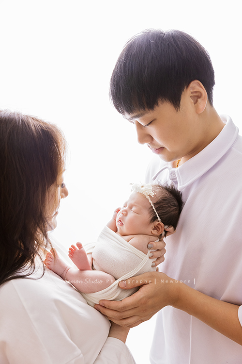 Fiamma一家第二次來拍照，這次是可愛的妹妹的新生兒寫真，這張是爸拔媽麻抱著二寶，兩人看著二寶的樣子充滿了愛！