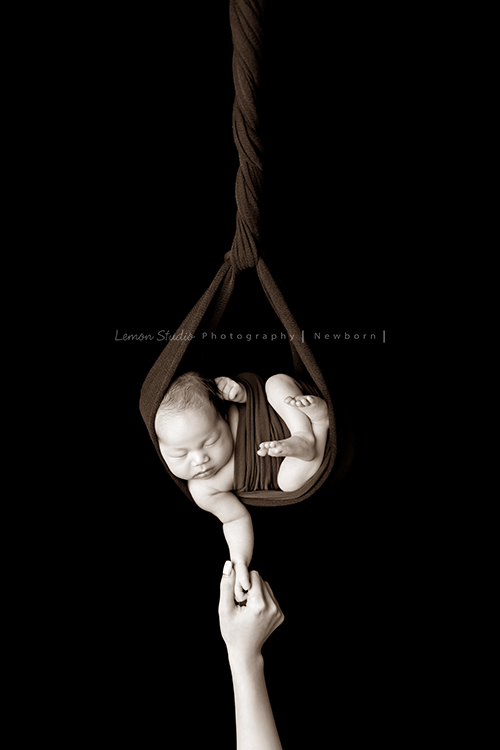 Fiamma一家第二次來拍照，這次是可愛的妹妹的新生兒寫真，這張是寶寶吊掛在紅色的布裡的黑白新生兒寶寶寫真！非常有藝術感、特別的相片！