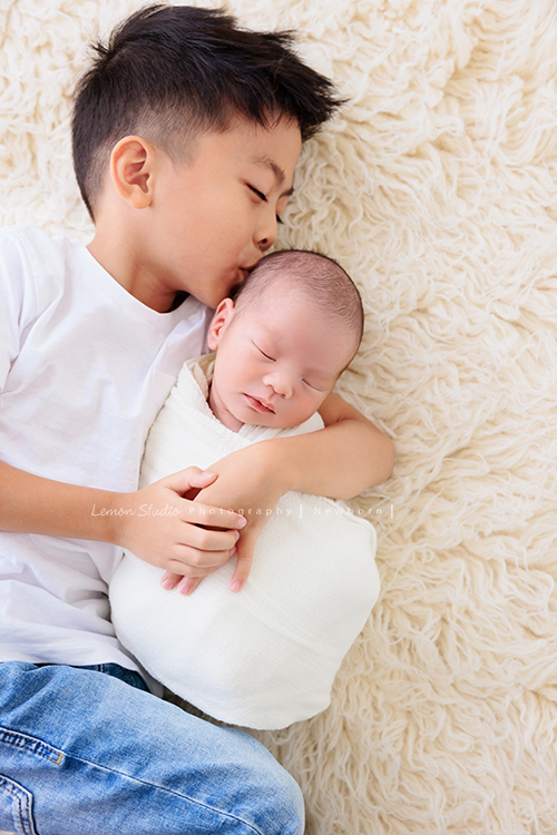 Renee媽麻一家第三次來拍照！這次是可愛的弟弟出生的新生兒寫真拍照紀念！全家一起入鏡！這張是哥哥抱著弟弟，親親弟弟的相片！