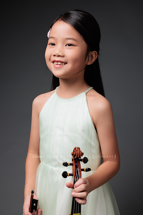 四位孩子來拍辦音樂會要使用的相片，現場嘰哩呱啦的，今天先放個兒最小年紀最小詩軒的相片，詩軒很期待這天的拍照，她拉起琴來很有自信超好聽的啊！這張是沒有看鏡頭微笑的詩軒！