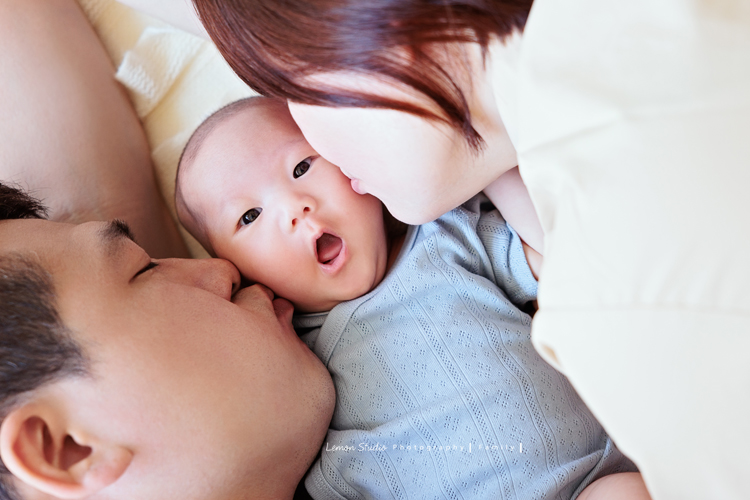 Ellie和先生帶著兩個月的寶貝及貓咪家人們來拍照，每一張相片都可以感覺到很舒服恬靜的幸福感，Eliie媽麻和先生也將平時的興趣帶入做為拍照的主題，這張是Ellie媽麻和先生親親寶貝的可愛相片！