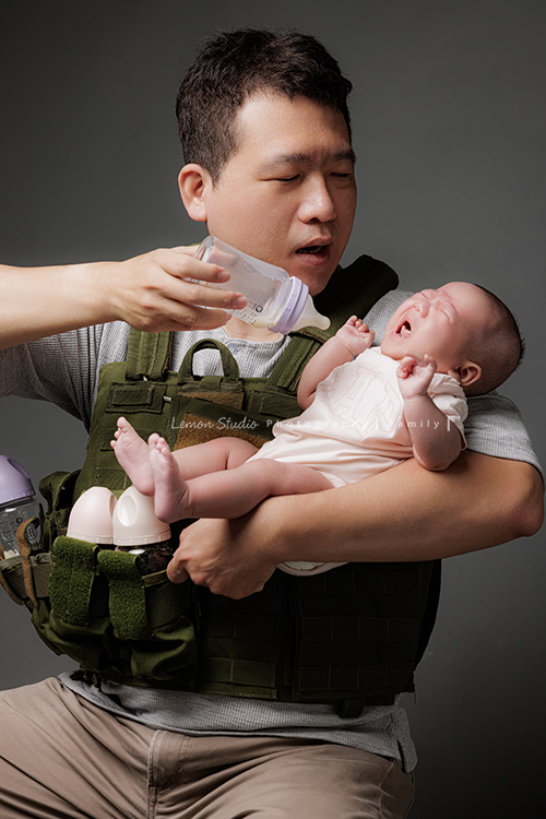 Ellie和先生帶著兩個月的寶貝及貓咪家人們來拍照，每一張相片都可以感覺到很舒服恬靜的幸福感，Eliie媽麻和先生也將平時的興趣帶入做為拍照的主題，這張是爸拔要餵寶貝喝奶的逗趣紀錄！