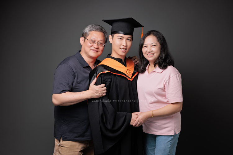 永憲和家妤碩士畢業來拍照，為要邁入人生的下一個階段做一個紀念，家人也一起入鏡拍了幾張合照，年長的奶奶也一起和孫兒拍了合照，這張是穿著碩士服的永憲和爸爸媽媽的合照！