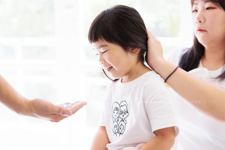 奕超爸拔帶著太太及四歲/兩歲的女兒們來拍照，兩人還特別準備了聖誕節應景的服裝道具，兩個女孩活潑又可愛，這張是媽麻正在幫姊姊綁頭髮的可愛紀錄！