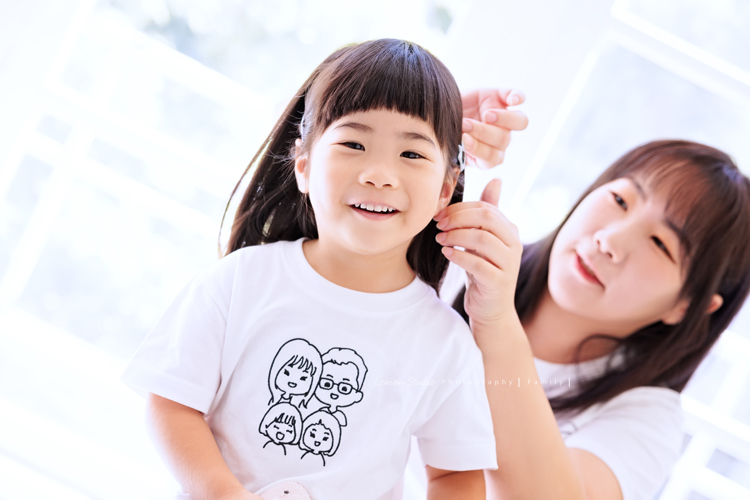 奕超爸拔帶著太太及四歲/兩歲的女兒們來拍照，兩人還特別準備了聖誕節應景的服裝道具，兩個女孩活潑又可愛，這張是媽麻正在幫姊姊夾頭髮的可愛紀錄！