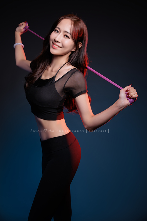 有三個孩子的孟菲，身材仍然保持地很好，這天除了拍正式的形象照，也拍了體態紀錄的形象照，這張是孟菲穿瑜伽服手拉著彈力帶的美麗體態紀錄形象照！