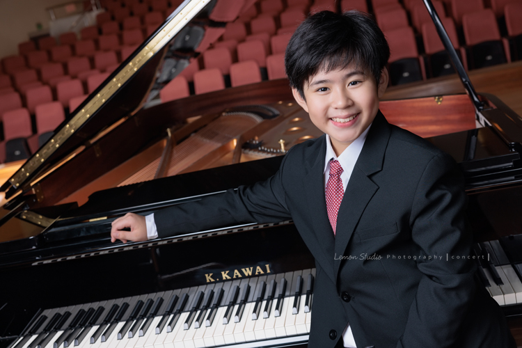 即將從國小音樂班畢業的晉瑋，提琴與鋼琴雙修，在音樂的薰陶下，從鏡頭裡看到他許多不同的情緒呈現，晉瑋的微笑已開始帶有青春期的帥氣，這張是晉瑋站在鋼琴旁笑得開心的音樂班畢業照之一！