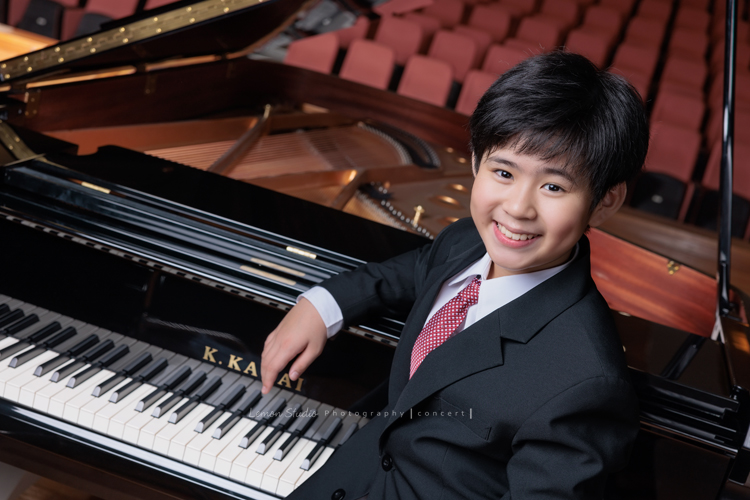 即將從國小音樂班畢業的晉瑋，提琴與鋼琴雙修，在音樂的薰陶下，從鏡頭裡看到他許多不同的情緒呈現，晉瑋的微笑已開始帶有青春期的帥氣，這張是晉瑋站在鋼琴鍵盤旁笑得開心的音樂班畢業照之一！