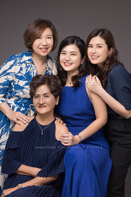 Corinne家三姊妹帶著媽媽從新加坡來台旅遊，也提早預約規劃好了這天來拍家庭寫真，美麗的三姊妹和媽媽這天預備好了一切前來，四人留下了好多好美且珍貴的互動紀錄與合照，這次的拍照會是Corinne三姊妹和媽媽珍藏一輩子的相片，這張是四人穿上藍色系的洋裝小禮服的美麗的全家福合照！