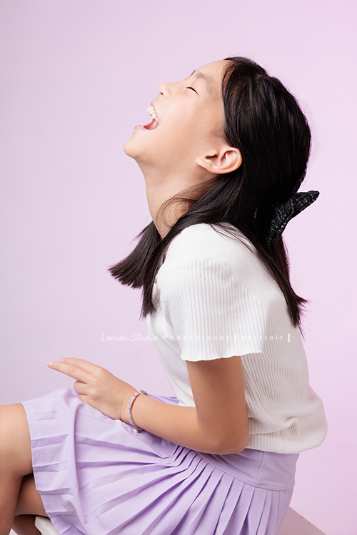 Cynthia媽麻的兩個可愛的女兒來拍寫真照，女孩們在鏡頭前很自然，拍起來不但很有質感，也抓到了兩個女孩許多不同的情緒與表情，這張是姊姊坐著側身笑的很開心的當下的個人寫真！