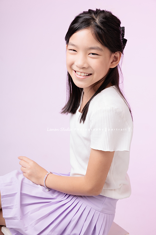 Cynthia媽麻的兩個可愛的女兒來拍寫真照，女孩們在鏡頭前很自然，拍起來不但很有質感，也抓到了兩個女孩許多不同的情緒與表情，這張是姊姊坐著側身看著鏡頭笑得很甜美的個人寫真！