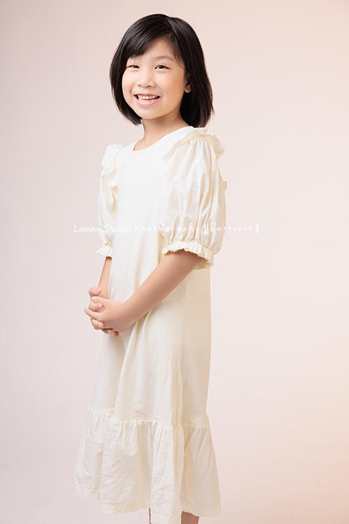 Cynthia媽麻的兩個可愛的女兒來拍寫真照，女孩們在鏡頭前很自然，拍起來不但很有質感，也抓到了兩個女孩許多不同的情緒與表情，這張是妹妹站著看著鏡頭甜甜地笑著的個人寫真！