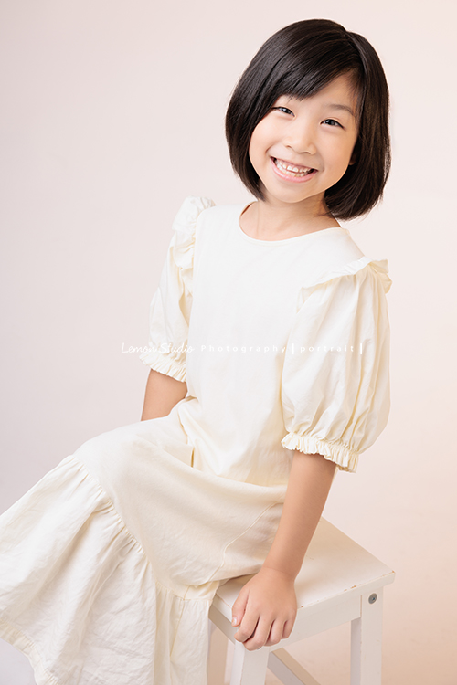 Cynthia媽麻的兩個可愛的女兒來拍寫真照，女孩們在鏡頭前很自然，拍起來不但很有質感，也抓到了兩個女孩許多不同的情緒與表情，這張是妹妹坐著看著鏡頭甜美地笑著的個人寫真！