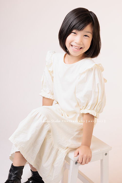 Cynthia媽麻的兩個可愛的女兒來拍寫真照，女孩們在鏡頭前很自然，拍起來不但很有質感，也抓到了兩個女孩許多不同的情緒與表情，這張是妹妹坐著看著鏡頭笑得很開心的個人寫真！