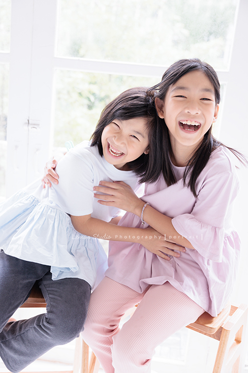 Cynthia媽麻的兩個可愛的女兒來拍寫真照，女孩們在鏡頭前很自然，拍起來不但很有質感，也抓到了兩個女孩許多不同的情緒與表情，這張是姊妹倆人坐在一起笑得非常燦爛抱在一起的紀錄寫真照！