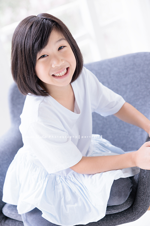 Cynthia媽麻的兩個可愛的女兒來拍寫真照，女孩們在鏡頭前很自然，拍起來不但很有質感，也抓到了兩個女孩許多不同的情緒與表情，這張是妹妹坐在椅子上笑容很可愛的寫真照！