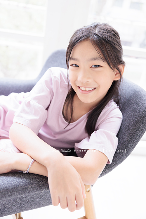 Cynthia媽麻的兩個可愛的女兒來拍寫真照，女孩們在鏡頭前很自然，拍起來不但很有質感，也抓到了兩個女孩許多不同的情緒與表情，這張是姊姊坐靠在椅子一邊、很有自信又甜美的寫真照！