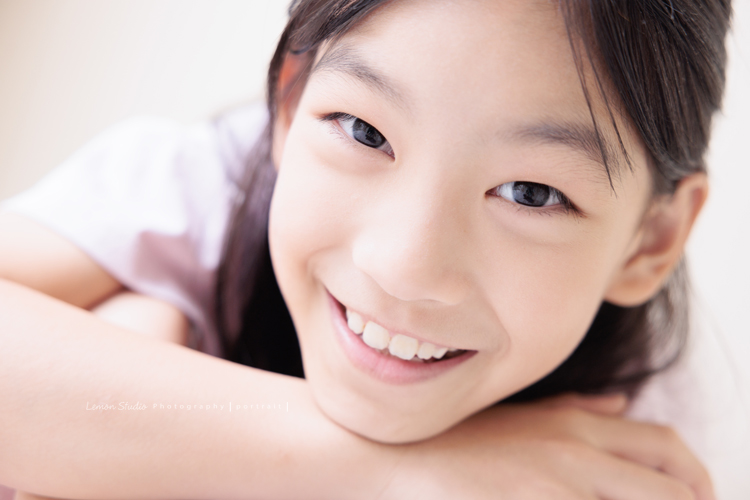Cynthia媽麻的兩個可愛的女兒來拍寫真照，女孩們在鏡頭前很自然，拍起來不但很有質感，也抓到了兩個女孩許多不同的情緒與表情，這張是姊姊看著鏡頭笑容很甜美的一張臉部特寫寫真照！