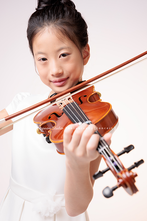 拉中提琴的晨紜和同學們這天一起來拍要辦音樂會使用的相片,這張是晨紜正在拉曲子的相片!