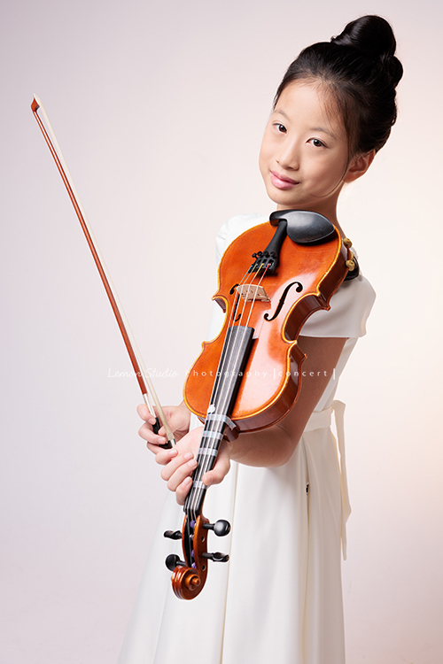 拉中提琴的晨紜和同學們這天一起來拍要辦音樂會使用的相片,這張是晨紜拉完曲子一手拿琴、一手拿弓的模樣!