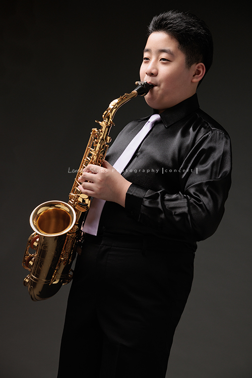 在同一個管樂團的軒＆宸兄弟檔來拍照，吹奏薩克斯風開朗的兩人，在鏡頭前很輕鬆自在地做自己，這張是弟弟宸站著吹奏薩克斯風的一張很帥氣的相片！
