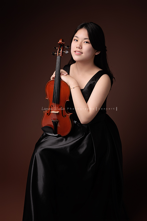 珍就讀於新竹的國小音樂班，即將畢業的她前來拍音樂班的畢業照寫真，身為首席的她，舉手投足之間散發著自信及沈穩，感受到她對於音樂的專注與熱愛，這張是珍坐在椅子上手扶著提琴看著鏡頭微笑的相片！
