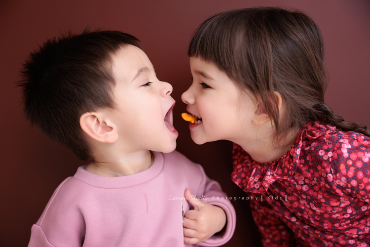 Emma媽麻一家來拍家庭寫真，四歲的姊姊琋和弟弟都是超可愛的混血兒，好喜歡這一系列相片抓到了很自然的每一個瞬間，紀錄一家的美好時刻！這張是姊姊咬著餅乾要傳給弟弟的一瞬間紀錄，弟弟張大嘴巴的樣子好可愛啊！