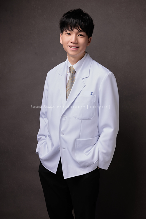 醫學院大四的宏來拍授袍紀念照，多才多藝的宏也帶了提琴入鏡，同時也把建中的制服帶來穿了拍照留念，授袍是一個很重要的里程碑，年輕又帥氣的宏這次拍照，留下了很多很棒的相片留念，這張是宏手放在口袋裡、看著鏡頭微笑的一張授袍紀念照！
