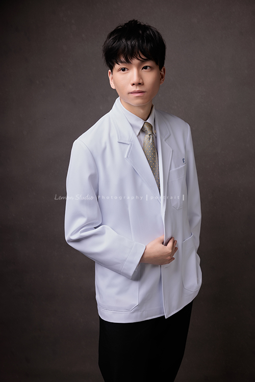 醫學院大四的宏來拍授袍紀念照，多才多藝的宏也帶了提琴入鏡，同時也把建中的制服帶來穿了拍照留念，授袍是一個很重要的里程碑，年輕又帥氣的宏這次拍照，留下了很多很棒的相片留念，這張是宏站著沒有看著鏡頭的一張帥氣的授袍紀念照！