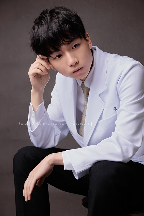 醫學院大四的宏來拍授袍紀念照，多才多藝的宏也帶了提琴入鏡，同時也把建中的制服帶來穿了拍照留念，授袍是一個很重要的里程碑，年輕又帥氣的宏這次拍照，留下了很多很棒的相片留念，這張是宏坐著沒有看著鏡頭的一張很有意境很帥氣的授袍紀念照！