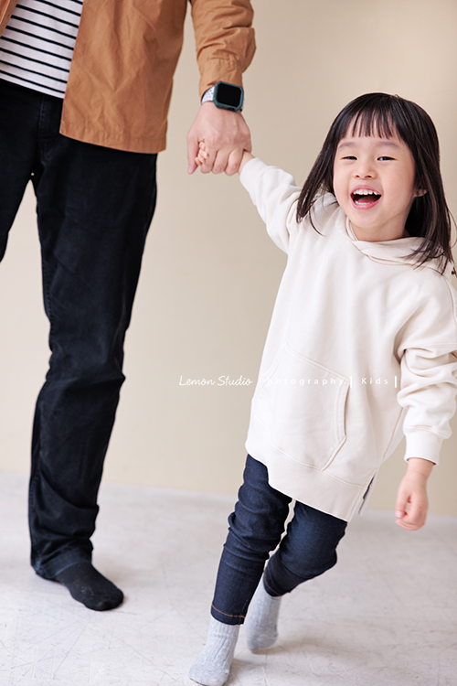 Jade媽麻一家來拍照，三歲八個月的姊姊、及八個月大的妹妹太可愛了，爸拔媽麻與姊妹倆玩得好開心，這張是姊姊牽著爸拔的手，姊姊很開心地笑著的一張紀錄！