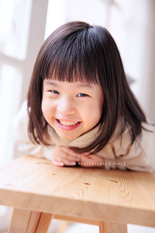 Jade媽麻一家來拍照，三歲八個月的姊姊、及八個月大的妹妹太可愛了，爸拔媽麻與姊妹倆玩得好開心，這張是姊姊趴在椅子上看著鏡頭很開心地笑著的相片！