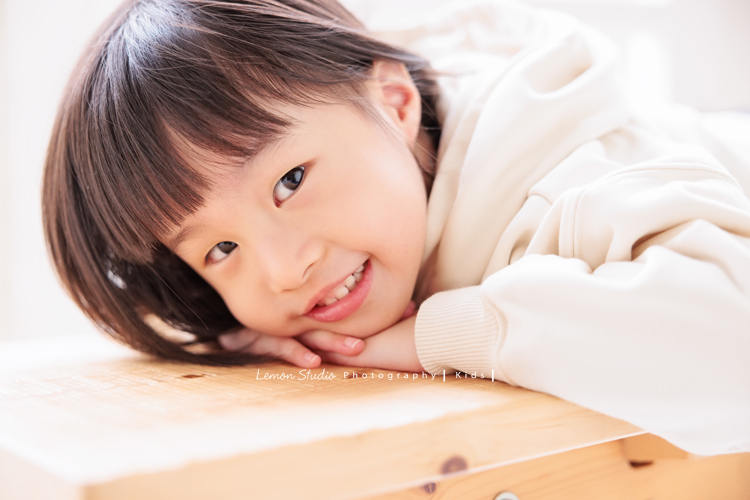 Jade媽麻一家來拍照，三歲八個月的姊姊、及八個月大的妹妹太可愛了，爸拔媽麻與姊妹倆玩得好開心，這張是姊姊趴在椅子上很可愛地看著鏡頭的一張個人寫真！