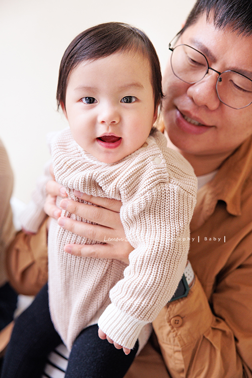 Jade媽麻一家來拍照，三歲八個月的姊姊、及八個月大的妹妹太可愛了，爸拔媽麻與姊妹倆玩得好開心，這張是爸拔抱著妹妹玩，妹妹瞪大雙眼看著鏡頭微笑的一張相片！