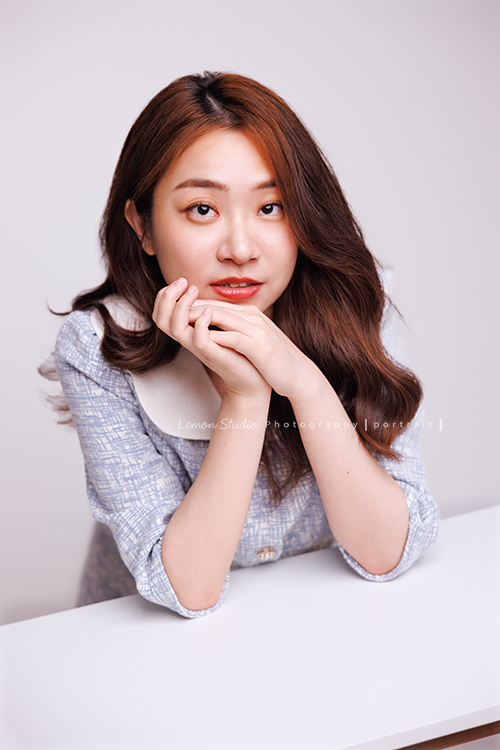 光程第三次來拍個人寫真,在電視新聞媒體業的光程,目前是寰宇新聞國際推播主播,光程好多角度都好美啊,這張是光程坐在一個桌子前,手肘放在桌上自然地擺著pose酷酷地看著鏡頭一張很美的個人寫真照!