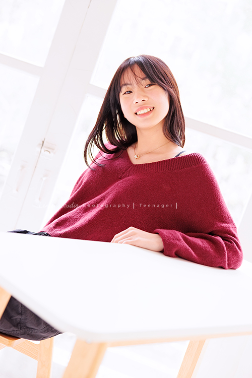 麗惠媽麻一家第四次來拍家庭寫真，第一次拍照是在15年前，當時Miranda & Charlotte都還是小小孩啊，如今姊妹倆已是美少女，這張是妹妹坐在桌子前面，看著鏡頭笑得很美的一張妹妹的個人寫真照！