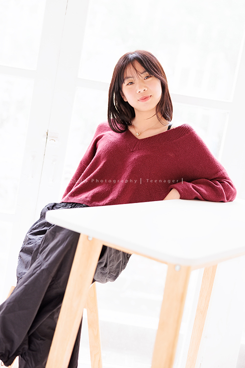 麗惠媽麻一家第四次來拍家庭寫真，第一次拍照是在15年前，當時Miranda & Charlotte都還是小小孩啊，如今姊妹倆已是美少女，這張是妹妹坐在桌子前面，看著鏡頭有點酷的表情，身體有優雅地坐著、很美的一張妹妹的個人寫真照！