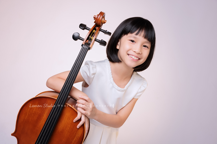 芯參加學校的弦樂團正在學習大提琴，為了即將來到的音樂會演出來拍音樂會寫真，雖然一開始拍照時有點小緊張，但逐漸地在鏡頭前越來越自在，結果捕捉到許多芯好可愛的表情及畫面，這張是芯站著手扶著大提琴很可愛地看著鏡頭微笑的一張音樂會寫真照！