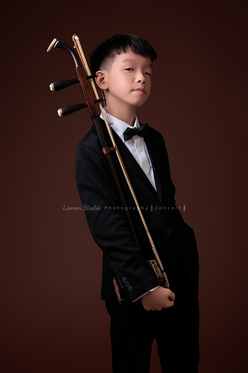 同時會拉小提琴及二胡的賢鐸來拍音樂會相片，賢鐸是學校的弦樂團A團首席及國樂全國賽特優學校二胡首席，這張是賢鐸站著一手拿著二胡、很有自信地看著鏡頭的音樂會相片！