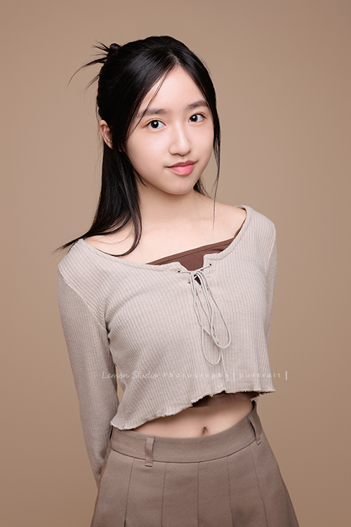 15歲的妤和姊姊分別來拍個人寫真紀念，今天分享的是妤的相片，這張是妤雙手放在身體後方、對著鏡頭微笑的一張很可愛的個人寫真照！