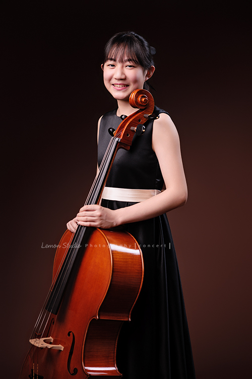 Lucie為了即將來到的音樂會帶著大提琴來拍音樂會寫真照，很有氣質的Lucie，拉琴時非常專注，Lucie笑起來很甜美，這張是Lucie站著手扶著大提琴甜美地笑著的七分身音樂會寫真照！