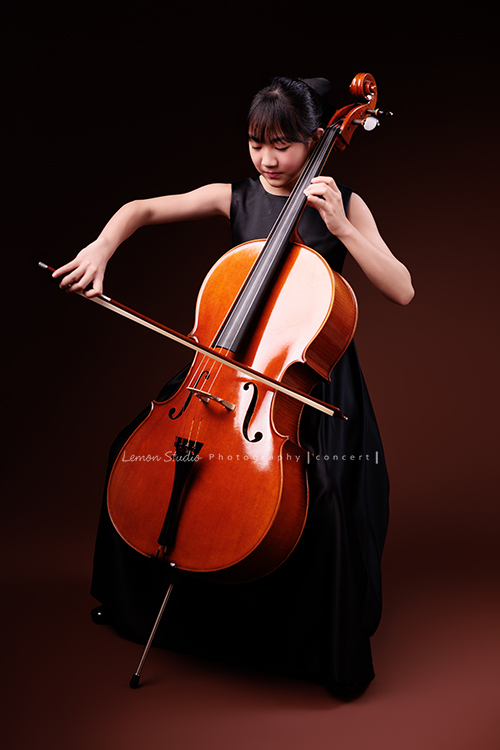 Lucie為了即將來到的音樂會帶著大提琴來拍音樂會寫真照，很有氣質的Lucie，笑起來很甜美，這張是Lucie坐在椅子上，酷酷地正專注地拉著大提琴的模樣！