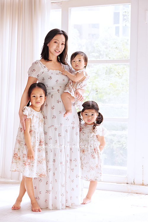 Katherine媽麻一家第三次來拍家庭寫真，這次回台灣多了第三個寶貝小妹，三姊妹在一起超可愛的，Katherine媽麻一家走自然風，喜歡很自然互動感覺的相片，我們也很喜歡啊，這張是媽麻和三姊妹穿同色系的洋裝，媽麻抱著三寶，兩位姊姊站在旁邊！四人的美麗合照！