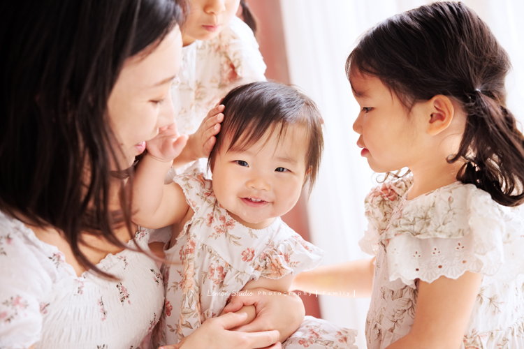 Katherine媽麻一家第三次來拍家庭寫真，這次回台灣多了第三個寶貝小妹，三姊妹在一起超可愛的，Katherine媽麻一家走自然風，喜歡很自然互動感覺的相片，我們也很喜歡啊，這張是媽麻和姊姊們正在和三寶玩，三寶看著鏡頭笑得很可愛啊！