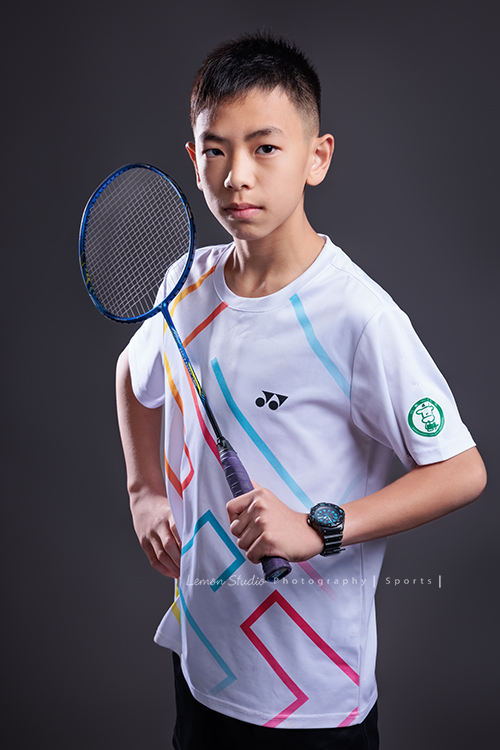 這次國小羽球隊請我們拍球隊的運動寫真照，運動的孩子們有一種很專注內斂的氣質，這次還有拍孩子們打球的瞬間，好有力量好美啊，這張是羽球隊裡一位男孩的運動寫真照，男孩一手拿球拍、一手叉腰，非常有自信堅定地看著鏡頭，很帥氣！