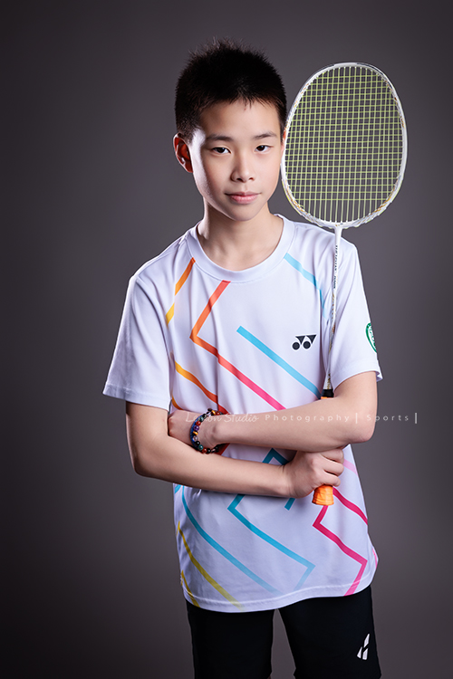 這次國小羽球隊請我們拍球隊的運動寫真照，運動的孩子們有一種很專注內斂的氣質，這次還有拍孩子們打球的瞬間，好有力量好美啊，這張是羽球隊裡一位男孩的運動寫真照，男孩一手拿球拍、兩手抱在前方，帶著微笑非常有自信堅定地看著鏡頭，很帥氣！