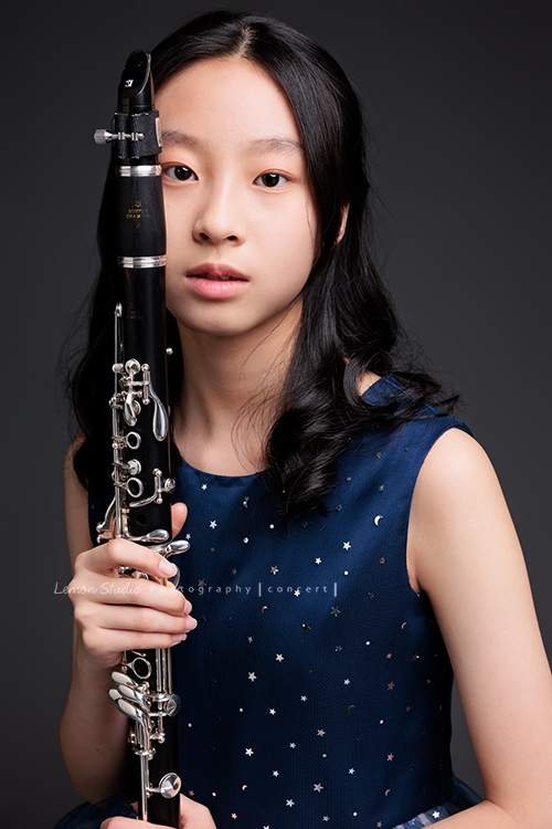 為了即將登場的音樂會，瑄帶著她的豎笛來拍攝音樂會寫真，穿上優雅的藍色系禮服，舉手投足間流露出屬於她的從容與氣質，這張是瑄雙手拿著豎笛放在臉旁，帶著空靈的氣質看著鏡頭的美麗模樣！