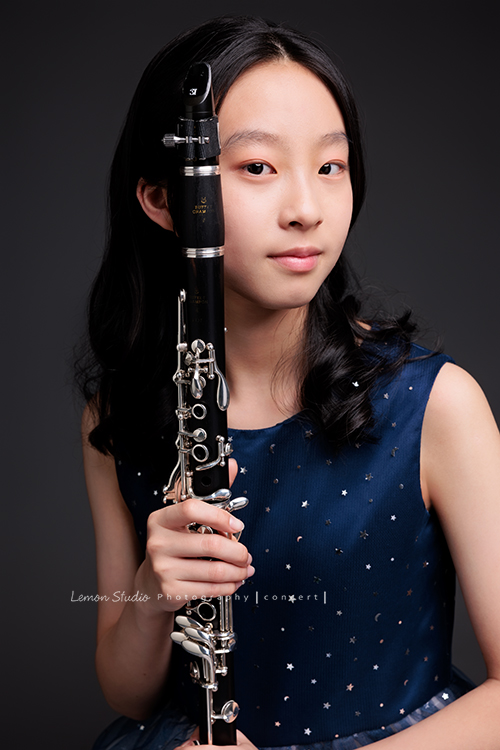 為了即將登場的音樂會，瑄帶著她的豎笛來拍攝音樂會寫真，穿上優雅的藍色系禮服，舉手投足間流露出屬於她的從容與氣質，這張是瑄雙手拿著豎笛放在臉旁，看著鏡頭微笑的美麗模樣！