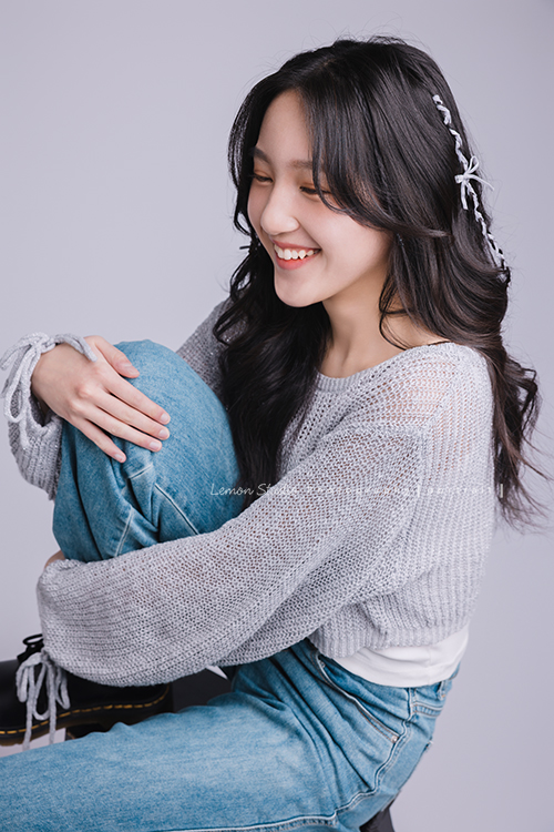 姊姊和妹妹分別來拍個人寫真，笑起來很甜美的姊姊很自在地做自己，在鏡頭前留下屬於這一刻的青春，這張是姊姊坐在椅子上、抬起一腳、兩首抱著腳、不看鏡頭笑得很甜美的一張很有意境的個人寫真！